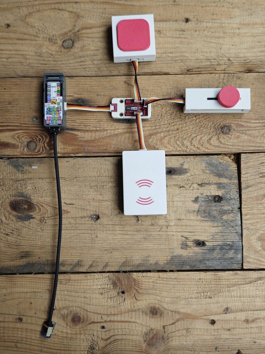 Bouton, fader, lecteur NFC reliés par câbles Grove à un module PoE — le câblage apparent